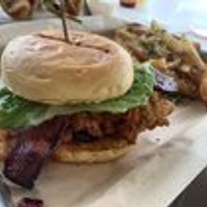 Preview thumbnail for Best chicken sandwich I’ve ever had; marinated and fried chicken thigh w/ Creole mayo, candied bacon, L&amp;T, and truffle fries on the side [North Beach Social, FL]